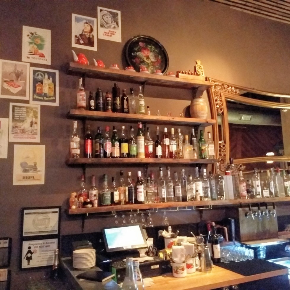 bar with bottles and a mirror at Kachinka