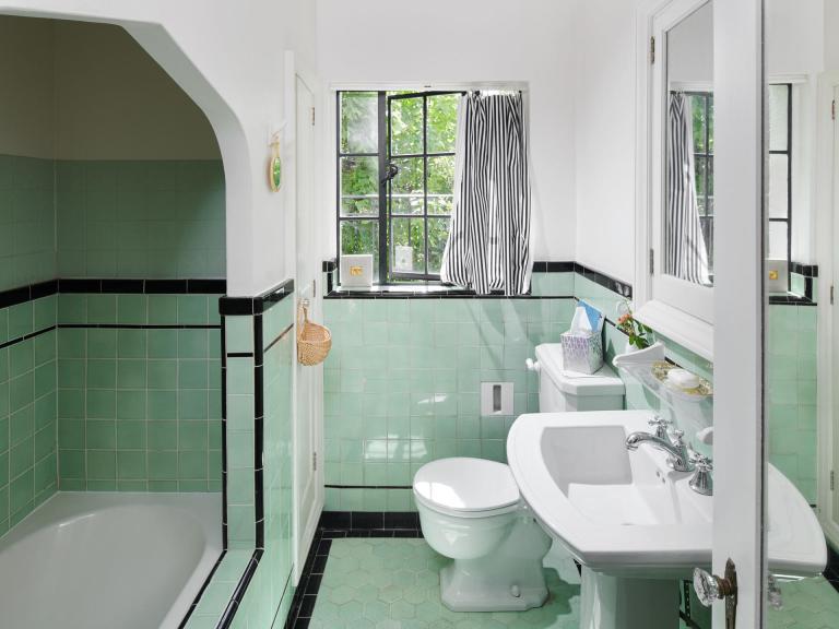 Vintage 1920s bathroom w/ pedestal sink, deco tiles and coved bath.