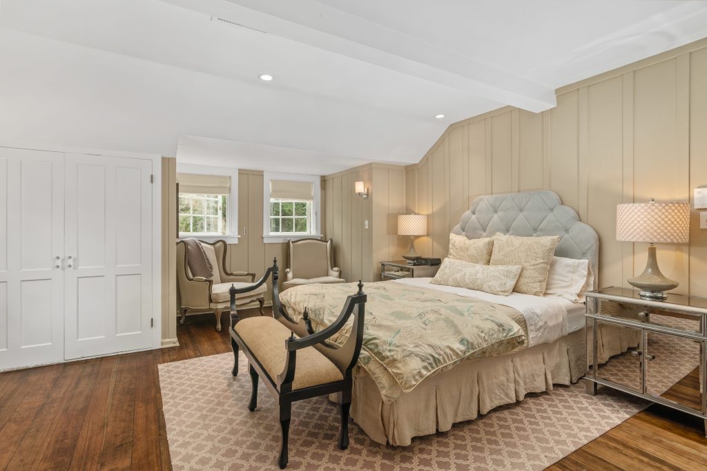 Master bedroom hardwood floors cozy bed beam ceilings