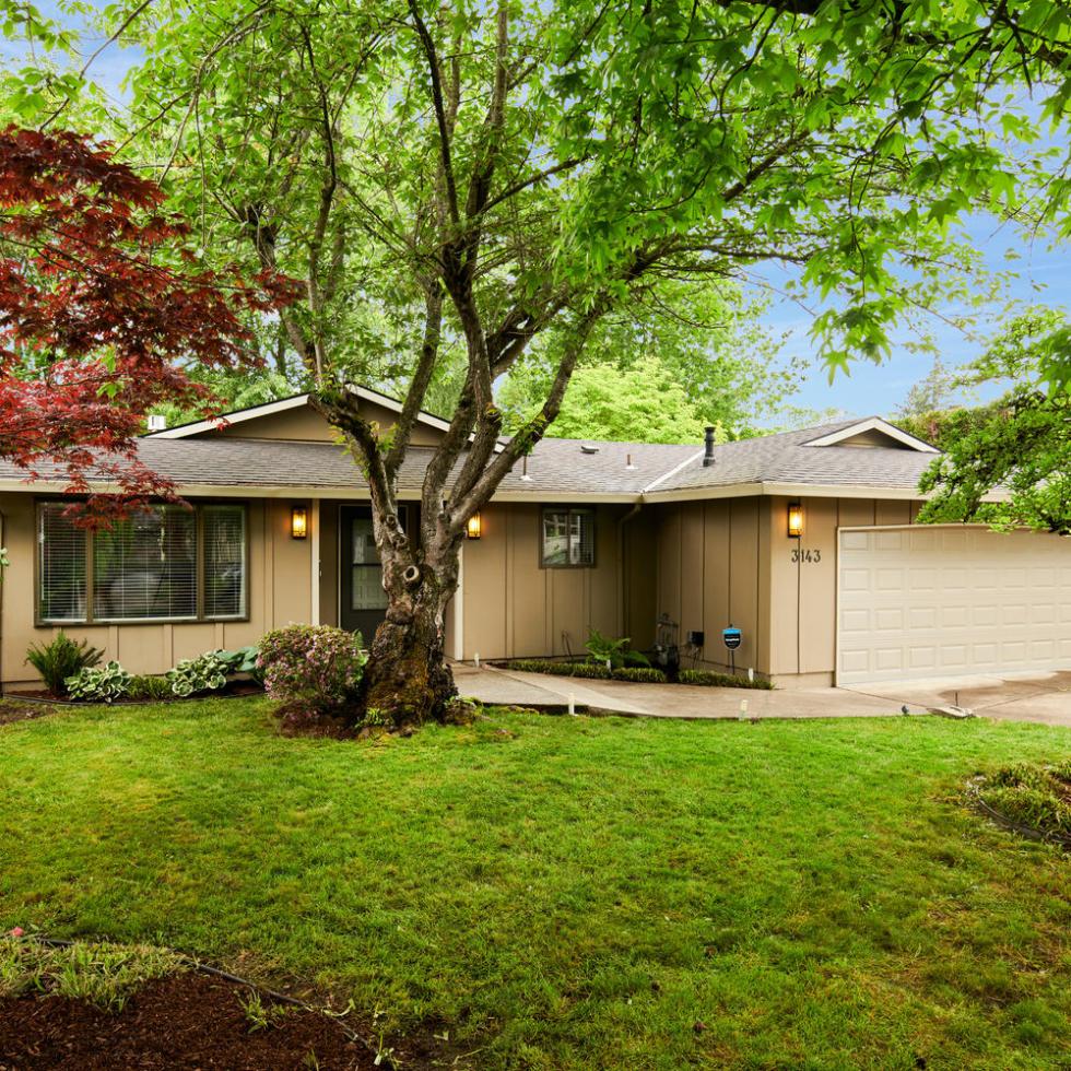 Exterior of house for sale in Portland Oregon in Laurelhurst with tree, grass and garage