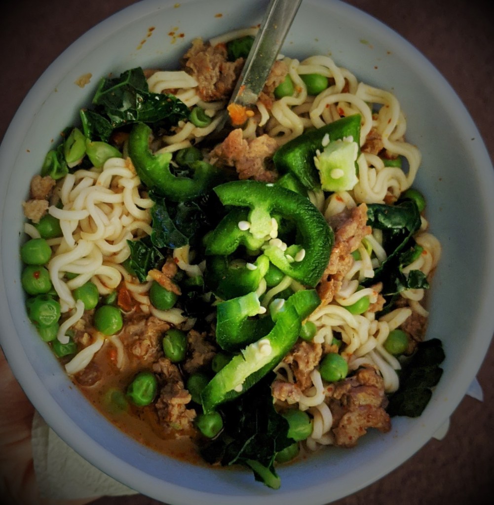A bowl of ramen noodles topped with Beyond Beef and jalapenos