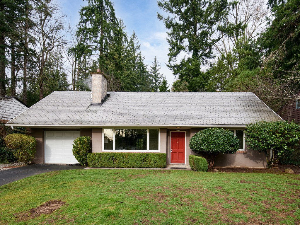 Exterior of a home with a red door and large green lawn