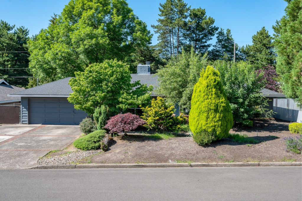 Exterior of gray home with greenery in front yard