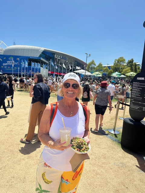 Susie holding a poke bowl and drink at the grounds of the Australian Open