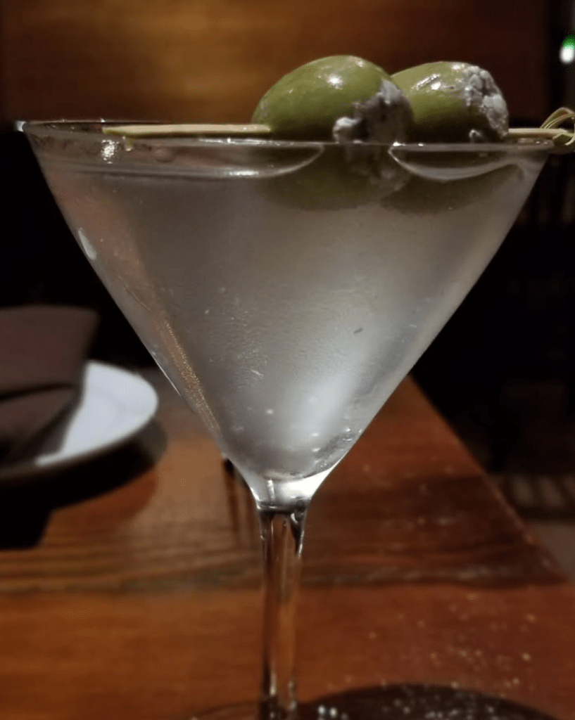 Cocktail photo of martini in a martini glass with stuffed blue cheese olives