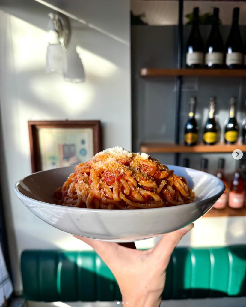 Hand holding a bowl of pasta
